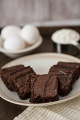 Brownies on a Plate With Eggs and Flour