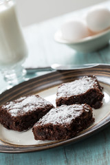 Three Brownies on a Plate With Eggs and a Cup of Milk