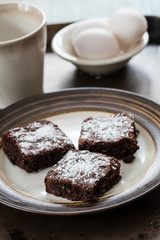 Three Brownies on a Plate With Eggs and a Coffee Mug