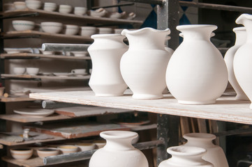 Fototapeta na wymiar Just enamelled vases ready to be painted in the workshop of a pottery artisan in Caltagirone