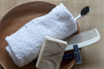 hygiene products - towel, soap, razor, tooth brush, comb, on the wood background.