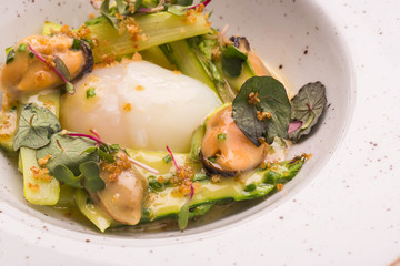 Asparagus with goose egg and sauce in a round plate