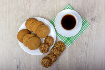 A cup of coffee and assorted cookies on the table.