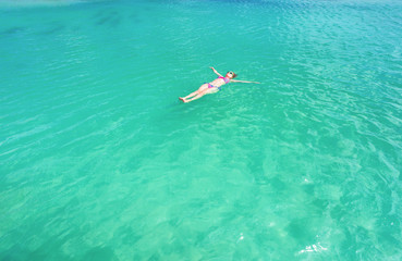 Woman floating on a back in the beautiful sea. Aruba island