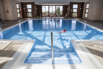 Little girl enjoying swimming pool indoors