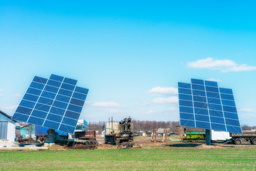 Solar panels on the green field in sunny weather. Vivid colorful image.