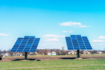 Solar panels on the green field in sunny weather. Vivid colorful image.