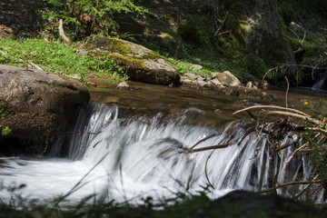 Waterfall on a mountain river in Carpathian Mountains , Romania