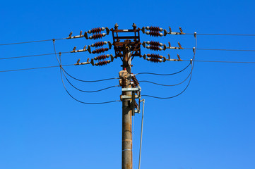 Electricity pylon for transmission of electricity and electric energy. Bright blue sky in the...