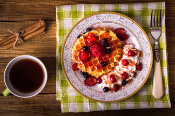 Waffle with fruit on a wooden background. Breakfast concept