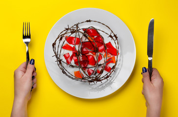 unhealthy food - barb wire and broken glass on a white plate