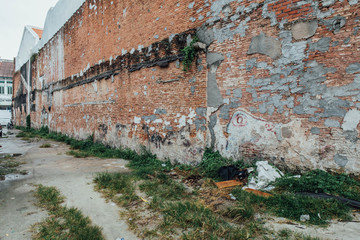 Red Brick Wall with Unfinished Wall Painted from The Street of George Town. Penang, Malaysia.