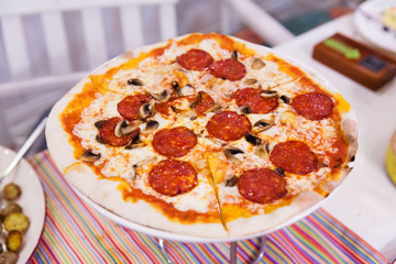 Pizza with salami, cheese and champignons