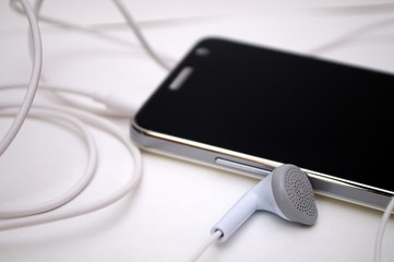 Photographing black phone with white headphones on a white background