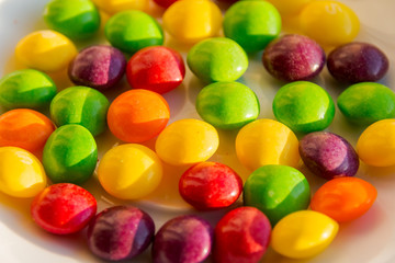 Closeup of the pile of colorful sweet bonbons. Scattered dragees of different colors. A colorful background.