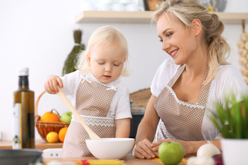 Obraz na płótnie Canvas Happy family in the kitchen. Mother and child daughter cooking tasty breakfast