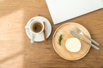 Coffee cup and Cheese cake on wood table from above.