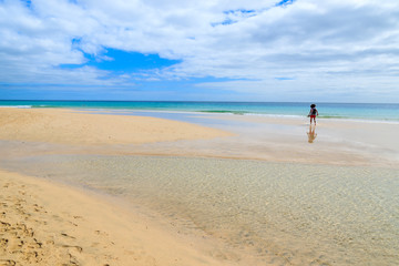Woman standing on Morro Jable beach on Jandia peninsula, Fuerteventura, Canary Islands, Spain
