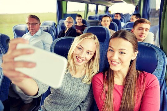 women taking selfie by smartphone in travel bus