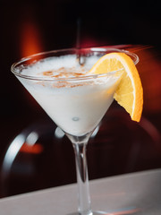 Cocktail with orange on bar desk, close-up.