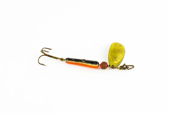 Exhibition of self-made fishing metal lures. Bait for fishing in the shape of a spoon with a hook on a white background.