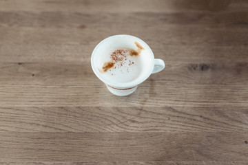 cup of coffee with milk on the wooden table