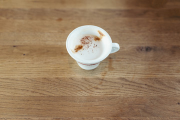 cup of coffee with milk on the wooden table