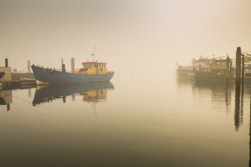 Fototapeta premium Fishing boats awaiting delayed departure in harbour due to heavy fog
