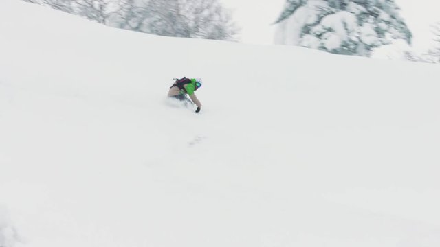 Snowboarding Riding Through Deep Powder Snow Goofy Foot Rider Slashing in Hokkaido Japan