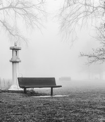 Fototapeta na wymiar Park bench in winter fog
