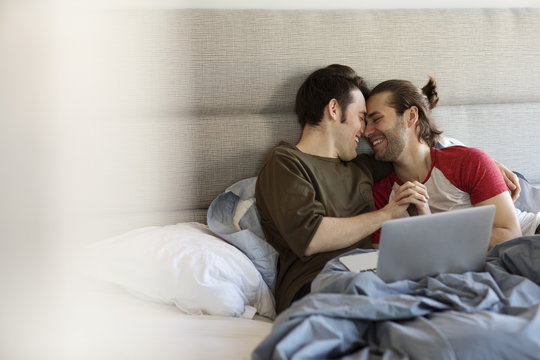 Gay couple romancing on bed