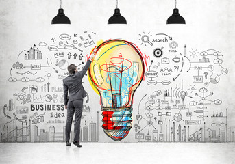 Man drawing light bulb and business icons