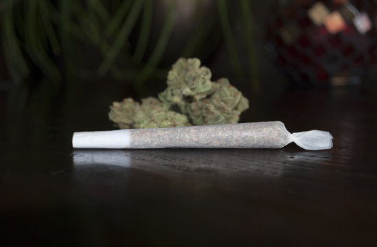 closeup of rolled marijuana weed joint on wooden background