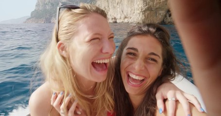 Girl friends taking selfie photograph while riding on speed boat with smartphone woman enjoying tropical beach nature background view on  summer vacation travel adventure POV - Powered by Adobe