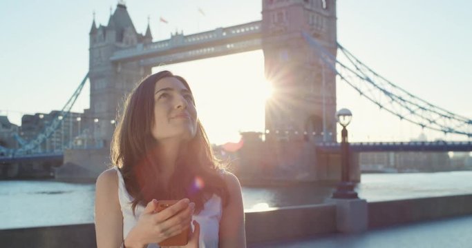 Tourist Woman holding smartphone in city  texting sharing lifestyle photo enjoying  holiday European   vacation travel adventure Tower Bridge London