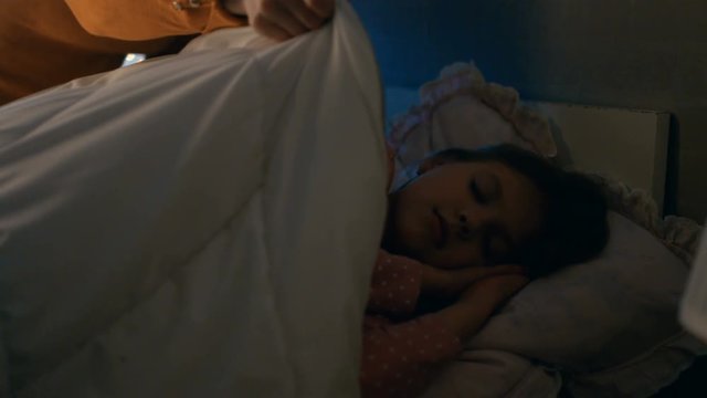 Mother Tucks in Her Cute Sleeping Girls.  Shot on RED EPIC-W 8K Helium Cinema Camera.