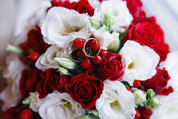 Wedding rings on the flowers of orchidsWedding rings on Bridal bouquet white red