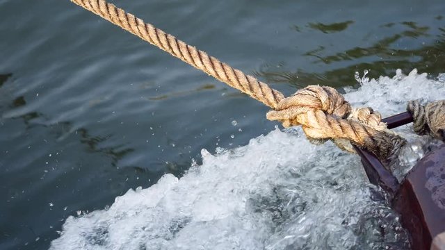 A knot of a rope from a travel raft that is drag by motor boat on the river Kwai, Thailand. 4K Movie