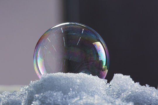 One colorful ice bubble sitting in snow in winter