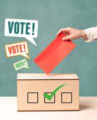placing a voting slip into a ballot box