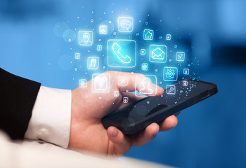 Hand holding smartphone with mobile app icons