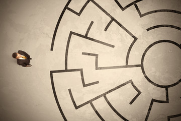 Lost business man looking for a way in circular labyrinth