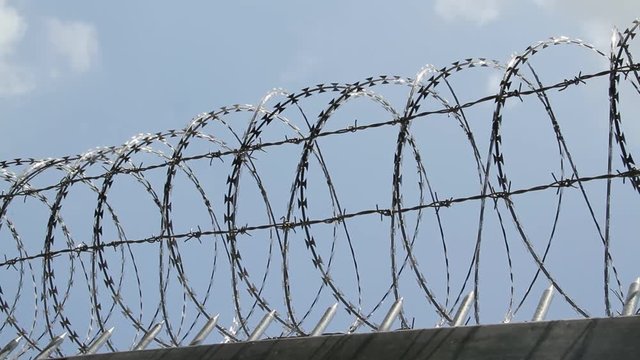 Barbed wire fence with cloud sky