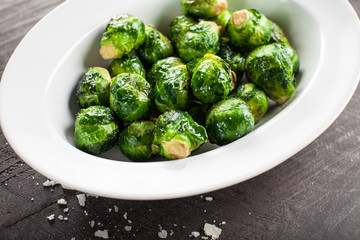 Oven roasted Brussels Sprouts with olive oil and salt on a dark wooden background