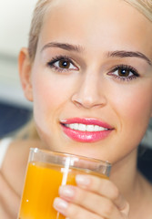 Portrait of woman with orange juice, indoors