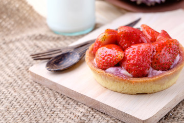 Tart with fresh strawberry on wooden background,