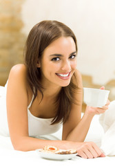 Smiling woman drinking coffee, at home