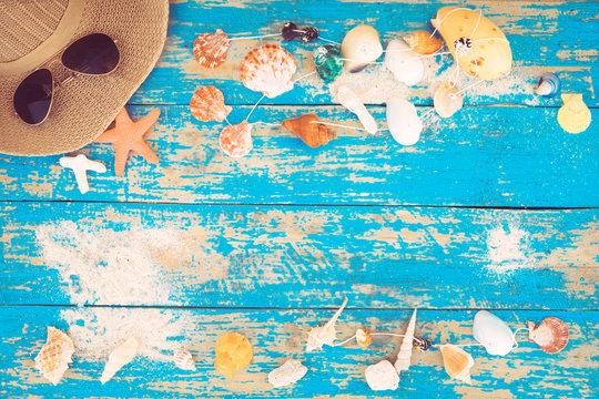 Summer background - The concept of leisure travel in the summer on a tropical beach seaside. sunglasses with starfish, shells, coral on wood table background.  vintage color tone styles.