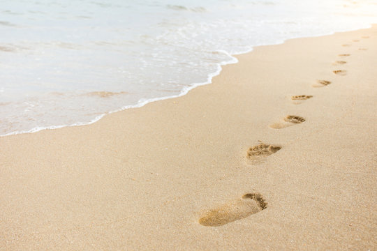 Foot print on sand at the beach background