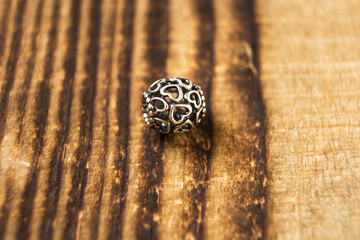 silver bead for bracelet on wooden background